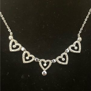 Silver necklace with 5 hearts adorned with clear crystals in their center